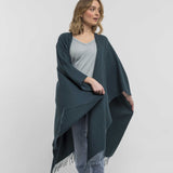 the Alicia Adams Alpaca Classic Cape, a timeless piece available in solid or herringbone patterns. With over 100 colors to choose from, it's perfect for any style preference. The cape effortlessly layers over sweaters and jackets, making it a must-have staple in every wardrobe.  This color is Spruce