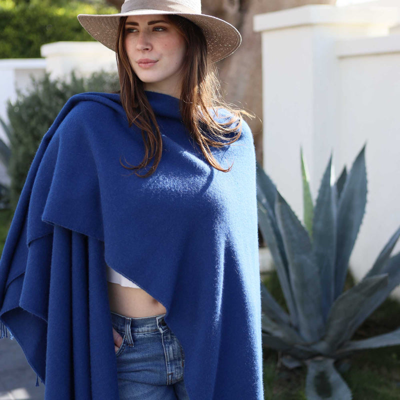 the Alicia Adams Alpaca Classic Cape, a timeless piece available in solid or herringbone patterns. With over 100 colors to choose from, it's perfect for any style preference. The cape effortlessly layers over sweaters and jackets, making it a must-have staple in every wardrobe.  This color is Blue Admiral